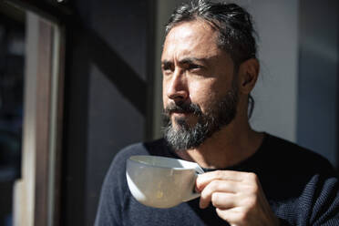 Nachdenklicher Mann mit Kaffeetasse in einem Cafe - JOSEF18602