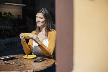 Frau mit Kaffeetasse am Tisch in einem Cafe sitzend - JOSEF18625