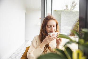 Lächelnde Frau riecht Kaffee im Hotel - PCLF00435