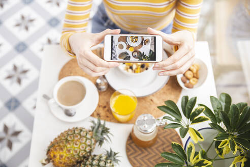 Woman photographing breakfast through mobile phone - PCLF00437