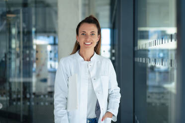 Confident doctor wearing lab coat at hospital - MOEF04554