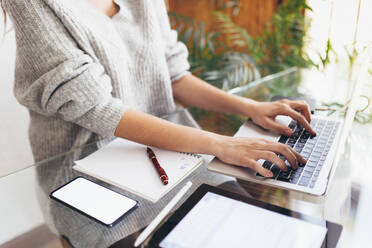 Geschäftsfrau arbeitet am Laptop im Büro zu Hause - EGHF00772