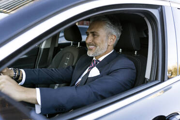 Smiling mature businessman driving car - JJF00786