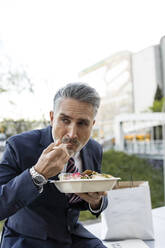 Businessman wearing suit eating lunch - JJF00848