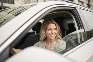 Kontemplative Frau im Auto sitzend - PNEF02702