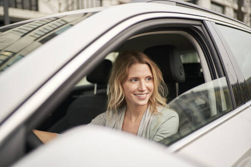 Contemplative woman sitting in car - PNEF02702