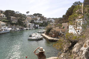 Frau betrachtet Boote am Liegeplatz von Cala Figuera, Mallorca, Spanien - FCF02126