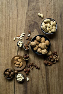 Studio shot of various nuts lying on wooden surface - ASF06855