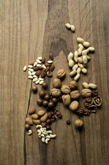 Studio shot of various nuts lying on wooden surface - ASF06856
