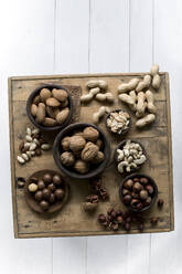 Studio shot of various nuts lying on wooden tray - ASF06857