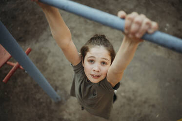 Boy hanging on monkey bar - ANAF01269