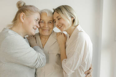 Women embracing grandmother at home - VIVF00604