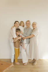 Multi-generation family standing in front of wall at home - VIVF00608