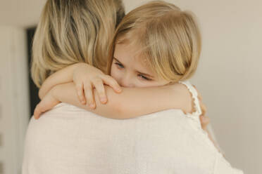 Traurige Tochter umarmt Mutter zu Hause - VIVF00611