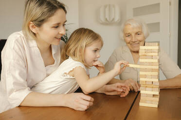 Mädchen spielt mit Familie zu Hause ein Spiel - VIVF00620