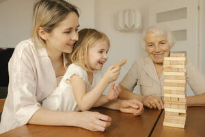 Happy daughter playing game with family at home - VIVF00621
