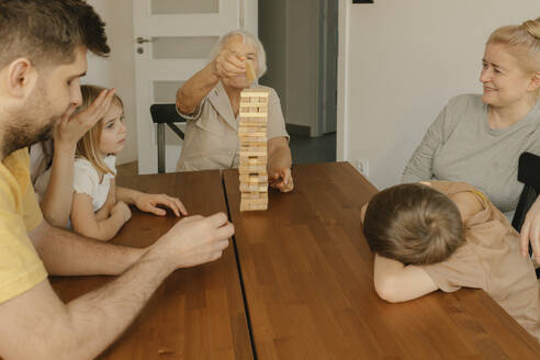 Multi-generation family enjoying game on table at home - VIVF00623