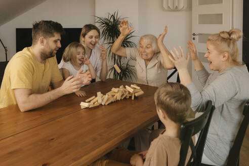 Mehrgenerationenfamilie bei einem Freizeitspiel am heimischen Tisch - VIVF00629