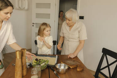 Mehrgenerationenfamilie bei der Zubereitung einer Mahlzeit zu Hause - VIVF00632