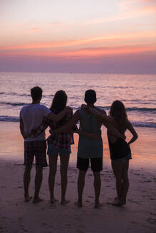 Freunde mit Arme um Blick auf Sonnenuntergang Blick auf den Strand - IKF00287