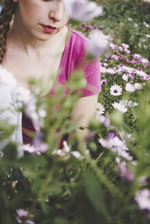 Frau inmitten von bunten Gänseblümchen auf einem Feld - SVCF00380