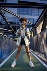 Smiling woman standing on bridge - IKF00310