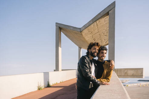 Gay couple standing near wall at sunny day - MMPF00735