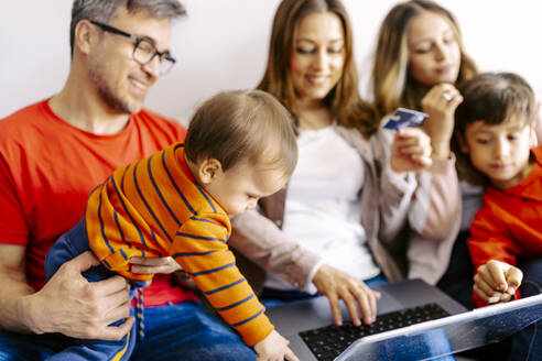 Die Familie verbringt ihre Freizeit gemeinsam mit dem Laptop zu Hause - JJF00886