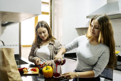 Tochter hilft Mutter bei der Zubereitung von Essen in der Küche zu Hause - JJF00927