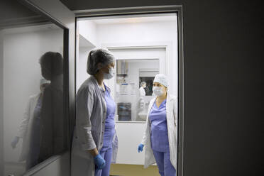 Chirurgen besprechen sich am Eingang des Operationssaals - SANF00094