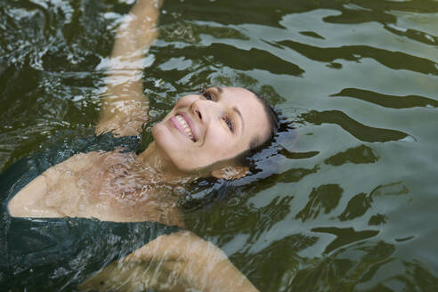 Reife Frau schwimmt auf Wasser im See - PNEF02809