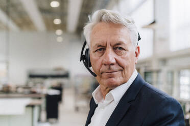 Senior customer service representative wearing headset in factory - JOSEF18810