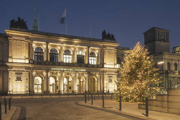 Germany, Hamburg, Christmas tree in front of Chamber of Commerce at dusk - KEBF02713