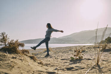 Carefree woman with arms outstretched enjoying at beach - ANNF00136