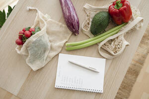 Einkaufsliste von frischem Gemüse in wiederverwendbaren Tüten auf dem Tisch zu Hause - ALKF00260