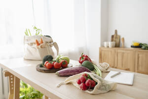 Frisches Gemüse in wiederverwendbaren Tüten auf dem Tisch zu Hause - ALKF00261