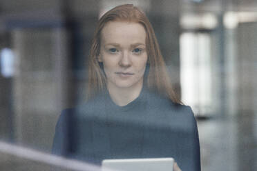Redhead businesswoman at office seen through glass - JOSEF18928
