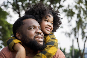 Contemplative girl leaning on father's shoulder - IKF00384