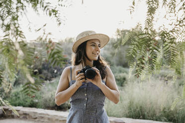 Lächelnde Frau mit Hut und Kamera - LHPF01544