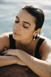 Frau mit nassen Haaren entspannt sich am Pool - LHPF01567