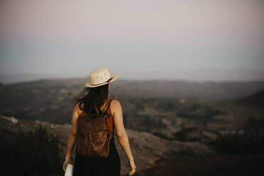 Woman with backpack looking at mountain - LHPF01579