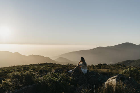 Woman admiring mountain at sunset - LHPF01583