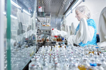 Wissenschaftlerin hält Chemikalienflasche in mikrobiologischer Sicherheitswerkbank - CVF02381