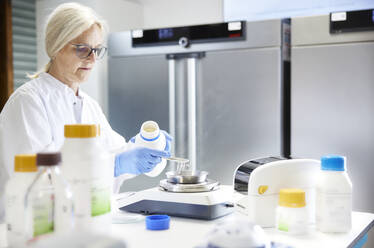 Scientist measuring chemical on weight scale in laboratory - CVF02383