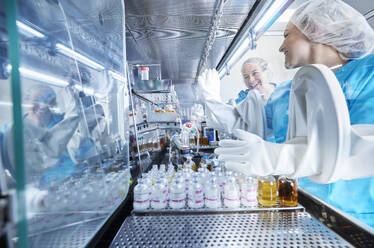 Chemiearbeiter geben sich in der mikrobiologischen Sicherheitswerkbank die Hand - CVF02390