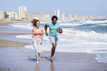 Glückliches Paar beim Laufen am Strand - JSMF02758