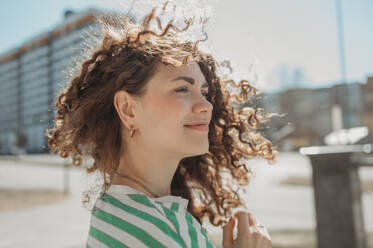 Smiling young woman with curly hair - ANAF01340