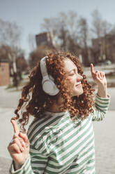 Frau tanzt und hört Musik über Bluetooth-Kopfhörer - ANAF01342