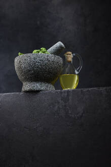 Studio shot of jug of olive oil and stone mortar - KSWF02364