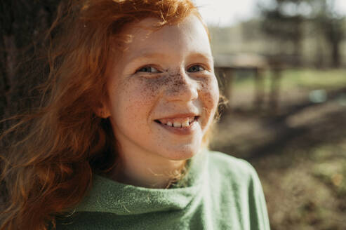 Smiling redhead girl with freckles on sunny day - ANAF01361